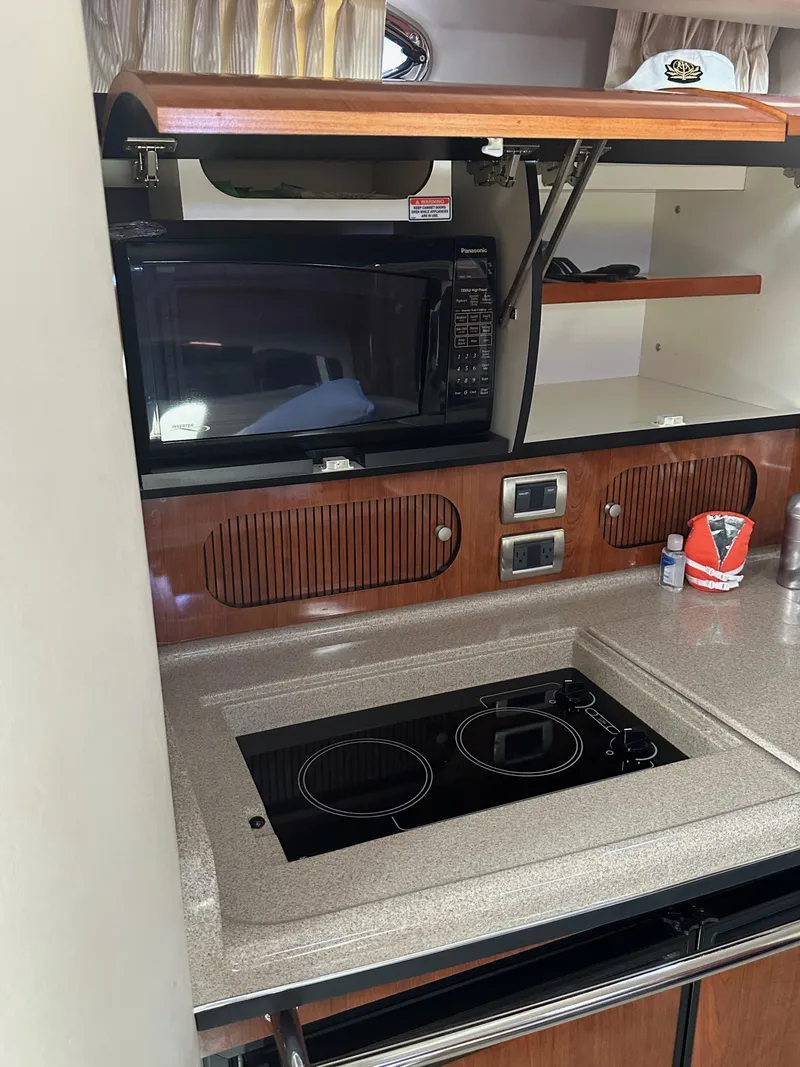 Slide: The Image of 2004 Sea Ray 360 Sundancer kitchen with microwave and stovetop. - 19