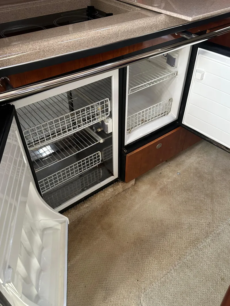 Slide: The Image of 2004 Sea Ray 360 Sundancer galley with open refrigerator and freezer compartments. - 20