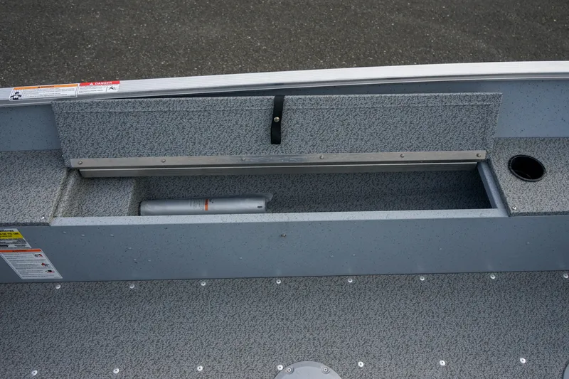 Slide: The Image of 2025 Lund 1600 Fury Tiller boat interior storage compartment, gray finish, open hatch. - 14
