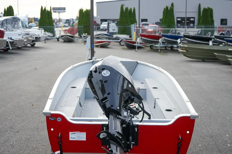 Slide: The Image of 2025 Lund 1600 Fury Tiller boat in a dealership lot, showcasing its outboard motor. - 3