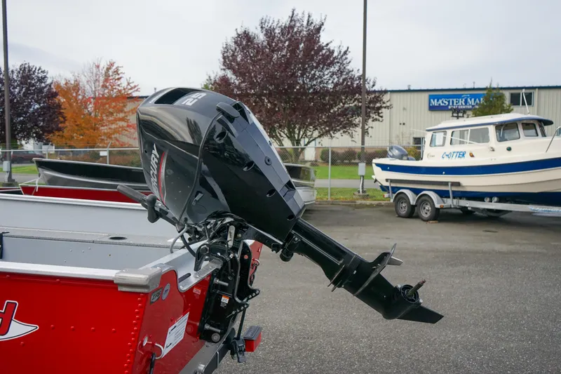 Slide: The Image of 2025 Lund 1600 Fury Tiller boat with outboard motor in a parking lot. - 4