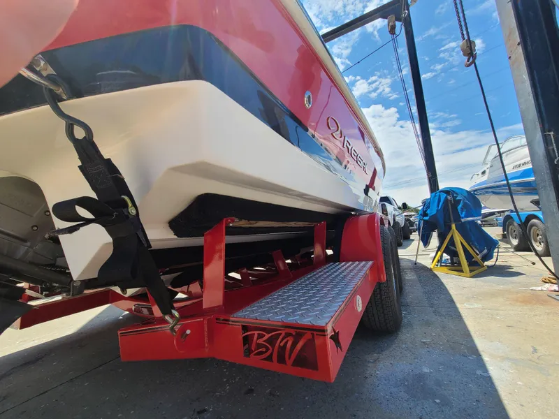Slide: The Image of 2007 Regal 2200 Bowrider on a red trailer, parked outdoors under a clear sky. - 13