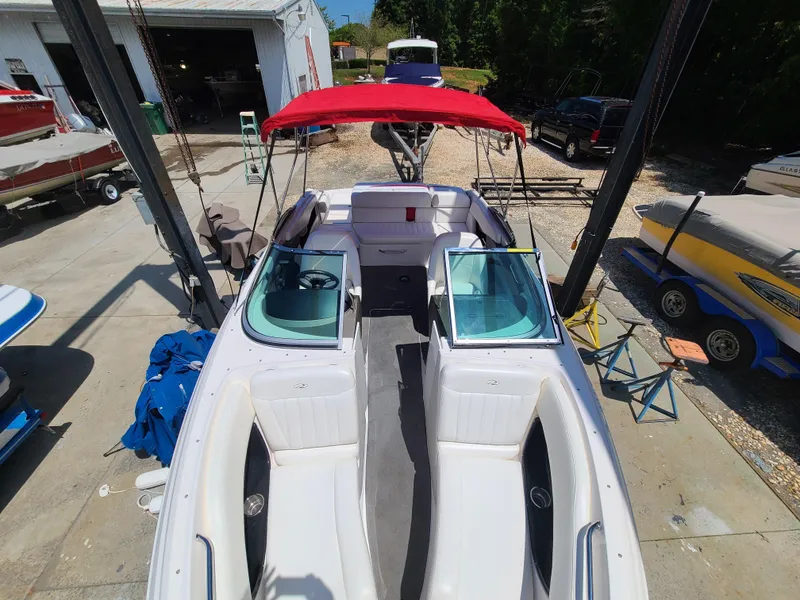 Slide: The Image of 2007 Regal 2200 Bowrider with red canopy, docked at a marina. - 14