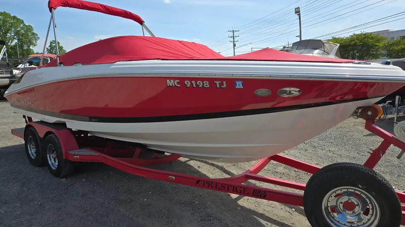 Slide: The Image of 2007 Regal 2200 Bowrider boat with red cover on a trailer. - 2