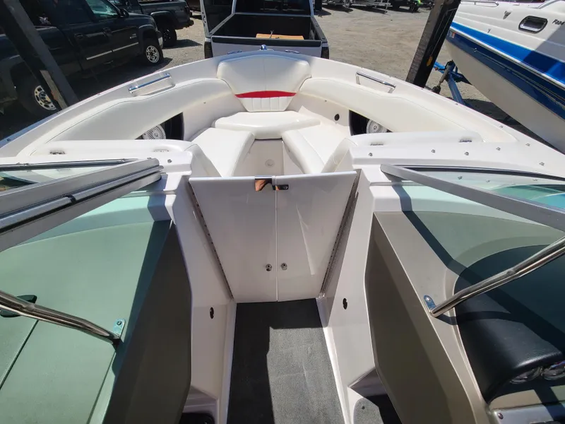 Slide: The Image of 2007 Regal 2200 Bowrider boat interior with seating and windshield, parked outdoors. - 22
