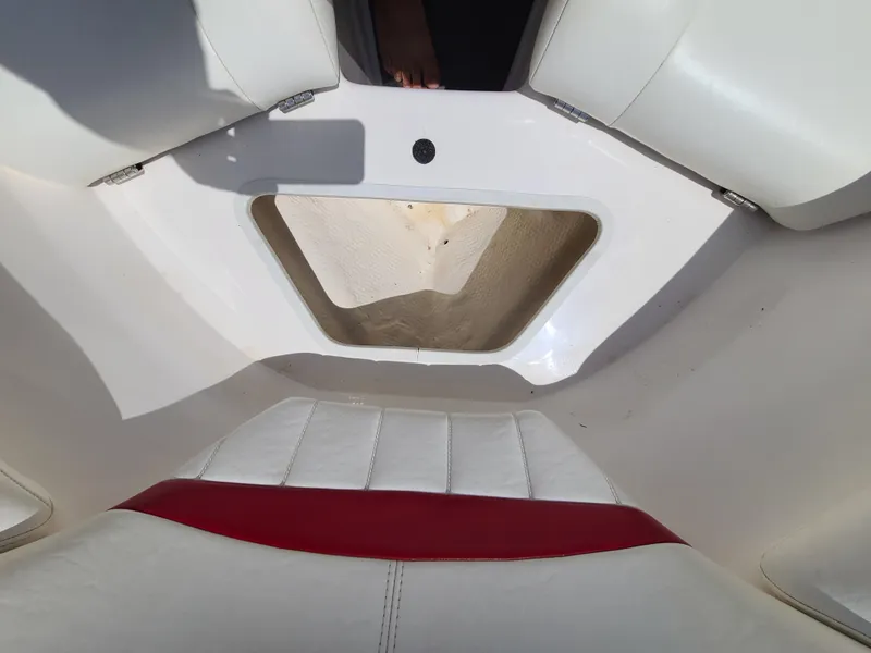 Slide: The Image of 2007 Regal 2200 Bowrider interior with white and red seating, showcasing storage compartment. - 38