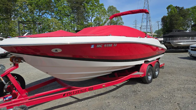 Slide: The Image of 2007 Regal 2200 Bowrider boat on a red trailer, parked outdoors. - 4