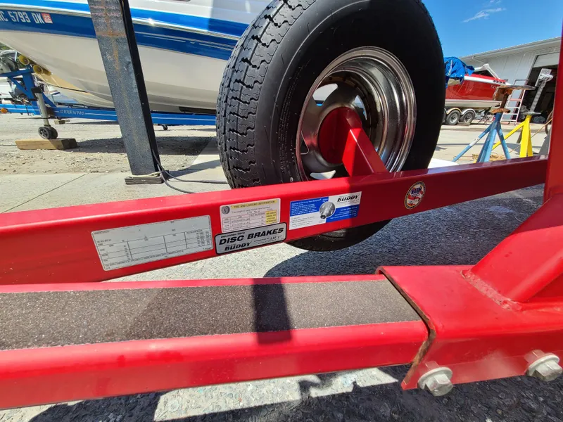 Slide: The Image of Red trailer with disc brakes label, supporting a 2007 Regal 2200 Bowrider boat. - 41
