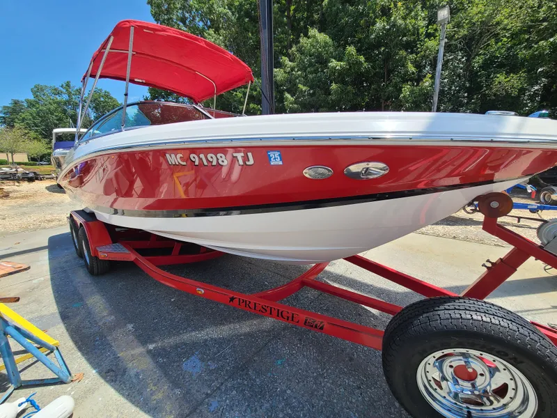 Slide: The Image of 2007 Regal 2200 Bowrider boat with red and white design on a trailer. - 5
