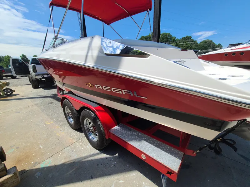 Slide: The Image of 2007 Regal 2200 Bowrider boat on a red trailer, parked outdoors. - 7