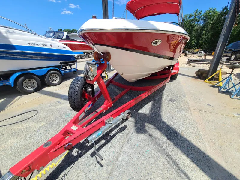 Slide: The Image of 2007 Regal 2200 Bowrider on red trailer, parked outdoors under clear blue sky. - 8