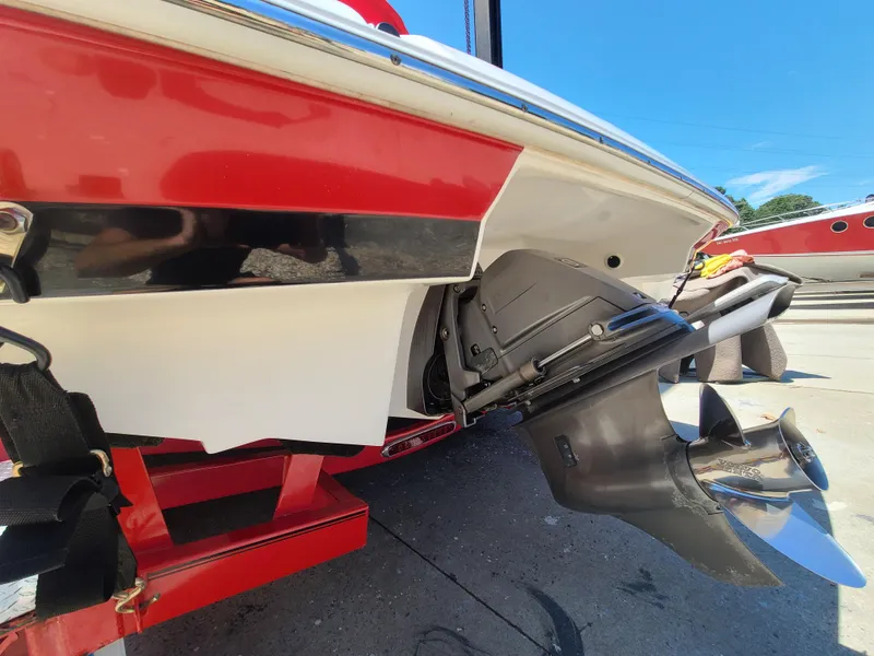 Slide: The Image of 2007 Regal 2200 Bowrider boat stern with propeller, red and white design, on trailer. - 9