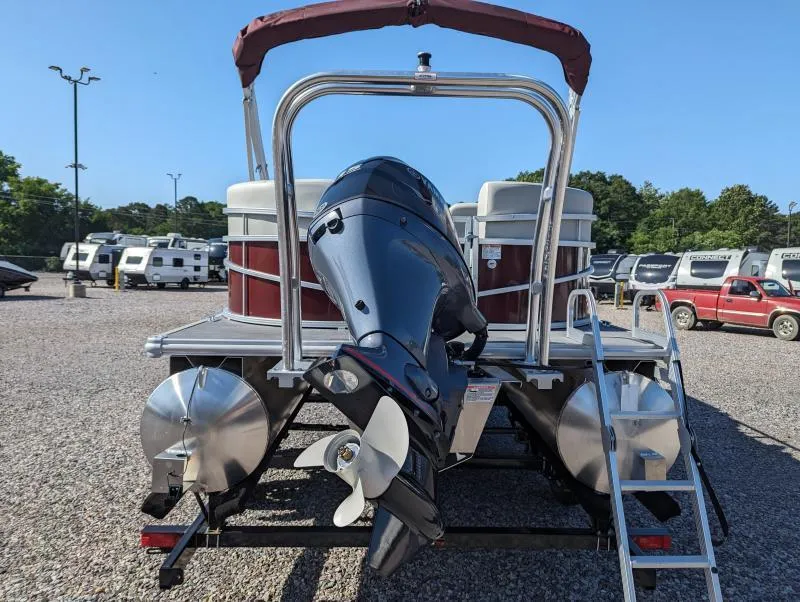Slide: The Image of 2024 SunChaser Vista 22 LR pontoon boat with outboard motor, parked on gravel lot. - 4