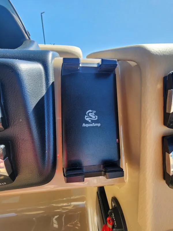 Slide: The Image of AquaAmp device on 2025 Harris Boats SUNLINER 230 dashboard under clear blue sky. - 14