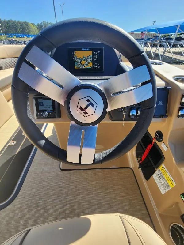 Slide: The Image of 2025 Harris Boats SUNLINER 230 steering wheel and dashboard with navigation display. - 19