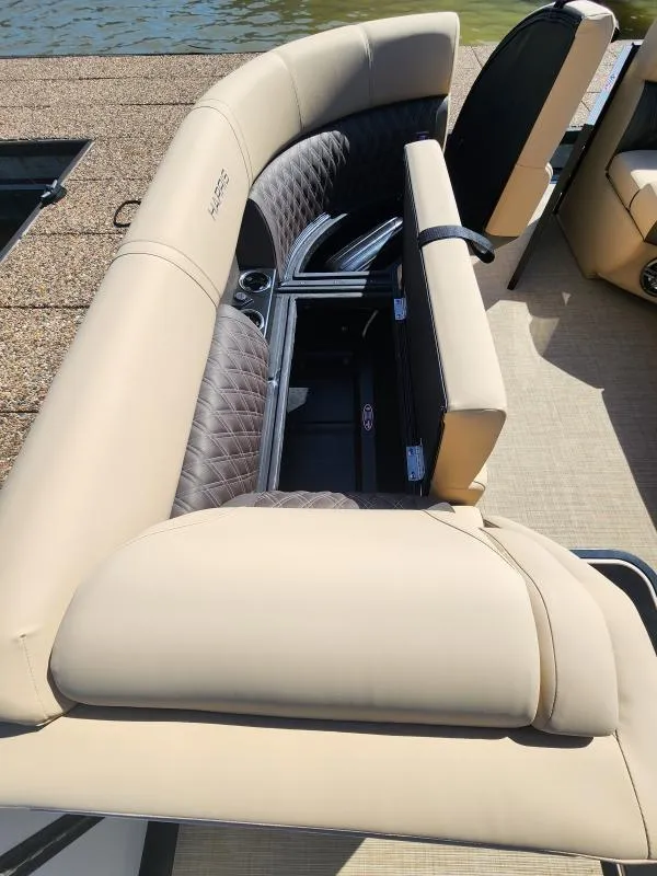 Slide: The Image of 2025 Harris Boats SUNLINER 230 with luxurious seating and storage, docked by the water. - 22
