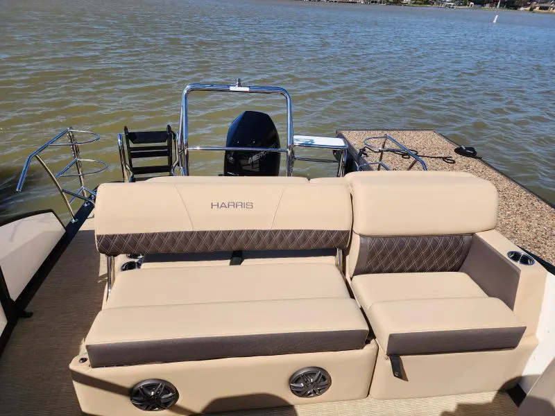 Slide: The Image of 2025 Harris Boats SUNLINER 230 with beige seating, on a calm lake. - 25