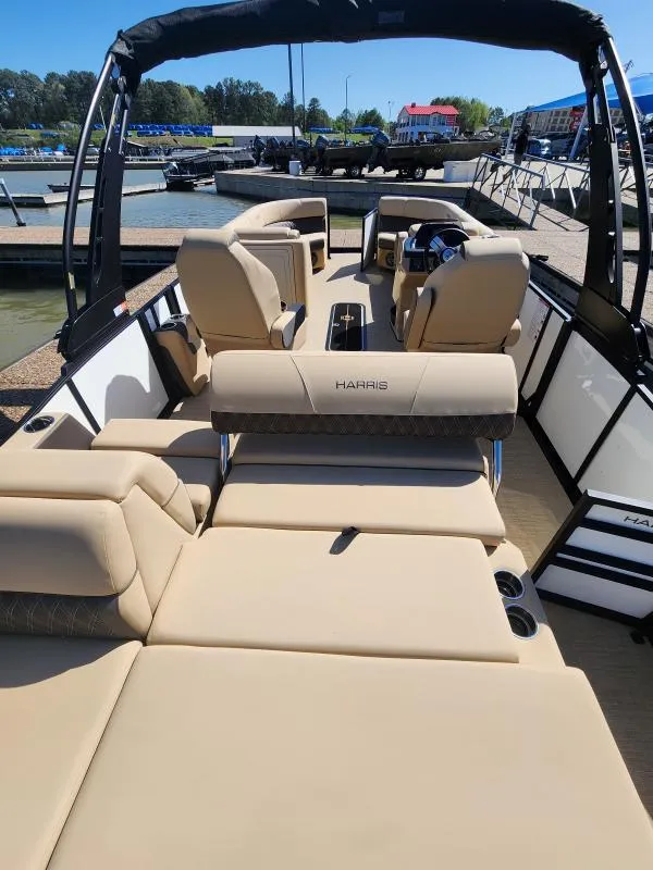 Slide: The Image of 2025 Harris Boats SUNLINER 230 with luxurious seating at a marina dock. - 5