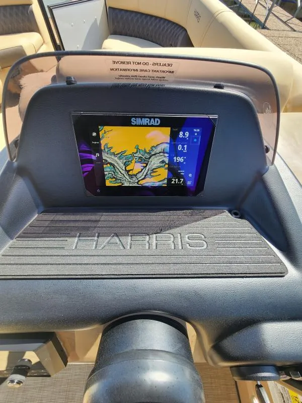 Slide: The Image of 2025 Harris SUNLINER 230 boat dashboard with Simrad navigation display. - 8