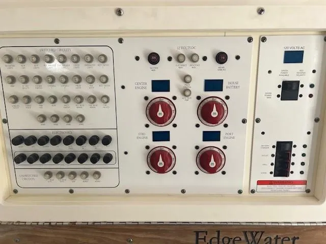 Slide: The Image of Control panel of a 2013 Edgewater 388CC boat with switches and dials. - 21