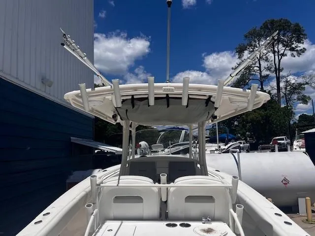 Slide: The Image of Edgewater 388CC 2013 boat with fishing rod holders, docked under a clear blue sky. - 25