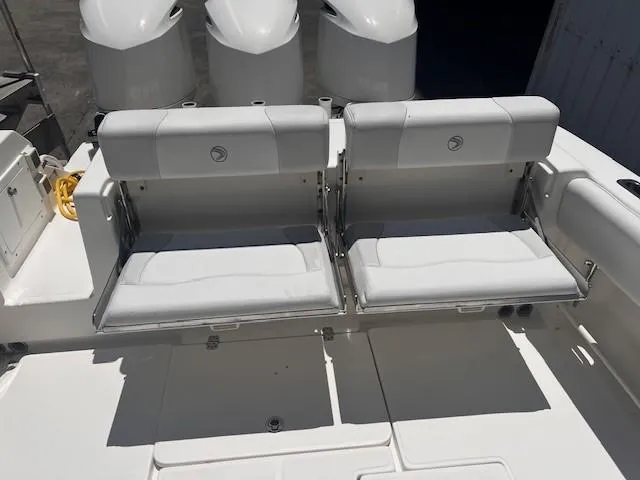 Slide: The Image of 2013 Edgewater 388CC boat with dual white cushioned seats and powerful outboard engines. - 28