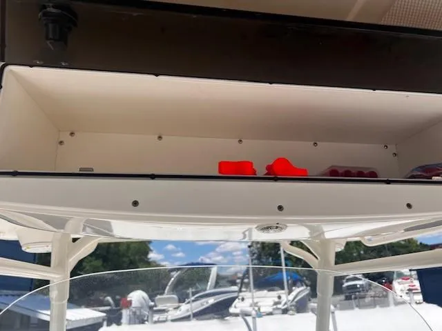 Slide: The Image of Open storage compartment on a 2013 Edgewater 388CC boat, with red items inside. - 32