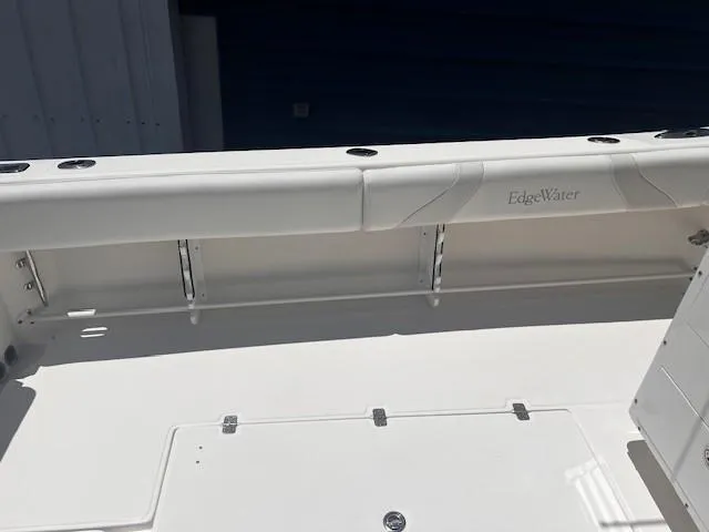 Slide: The Image of 2013 Edgewater 388CC boat interior with white seating and storage compartments. - 35