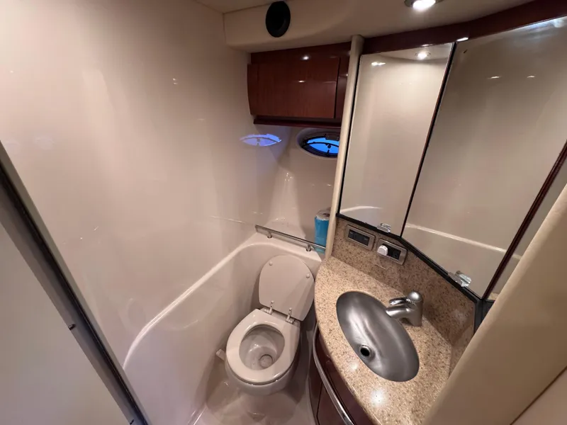 Slide: The Image of 2004 Sea Ray 420 Sundancer bathroom with toilet, sink, and mirror. - 23