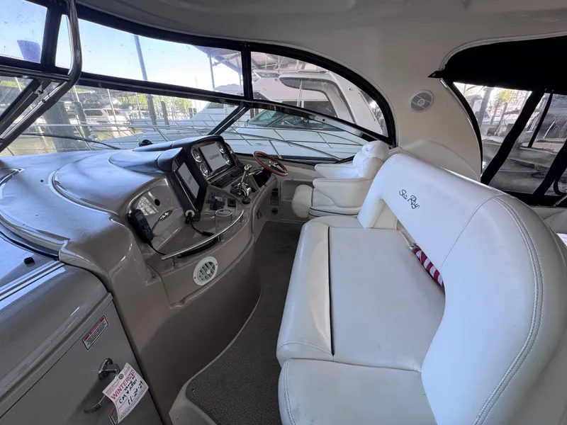 Slide: The Image of 2004 Sea Ray 420 Sundancer cockpit with white seating and modern control panel. - 8