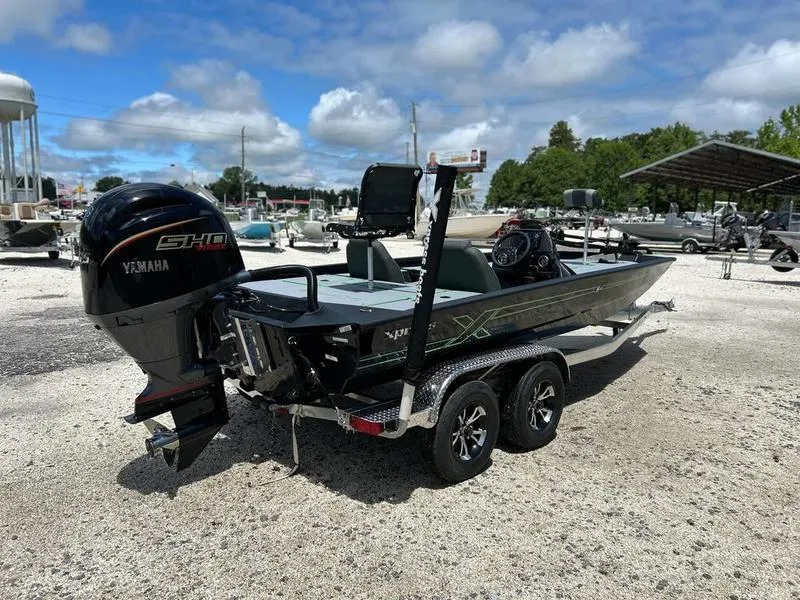 Slide: The Image of 2025 Xpress H20 Bass boat with Yamaha engine on a trailer, parked outdoors. - 5