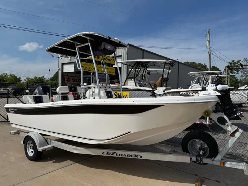 Slide: The Image of 2012 Carolina Skiff 19 Ultra boat on EZ Loader trailer, parked outdoors. - 2