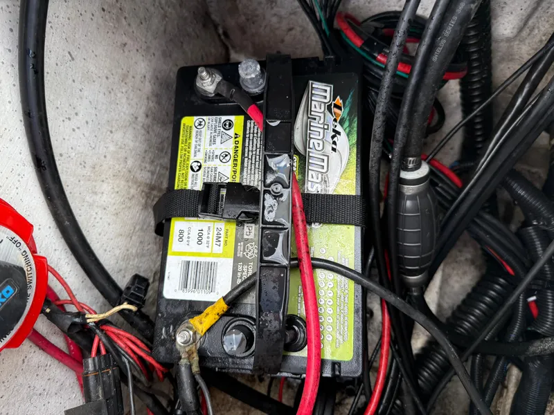Slide: The Image of Battery setup in a 2012 Carolina Skiff 19 Ultra boat with visible wiring connections. - 33