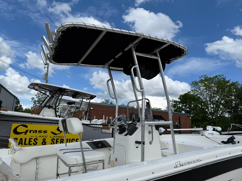 Slide: The Image of 2012 Carolina Skiff 19 Ultra boat with T-top, parked near sales and service sign. - 7