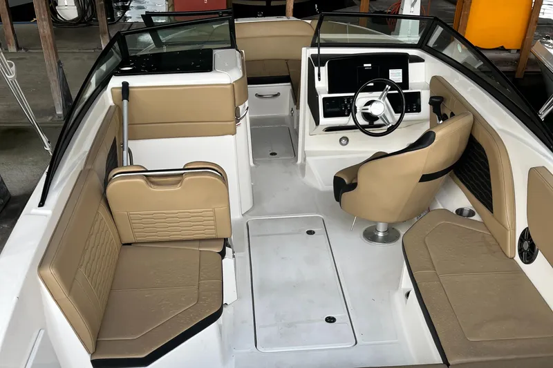 Slide: The Image of 2022 Sea Ray SPX 230 OB boat interior with tan seating and modern dashboard. - 14