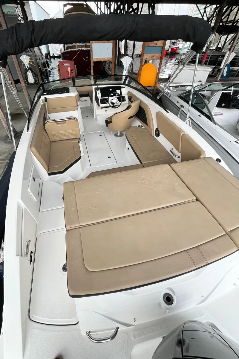 Slide: The Image of 2022 Sea Ray SPX 230 OB boat interior with beige seating and modern design. - 15