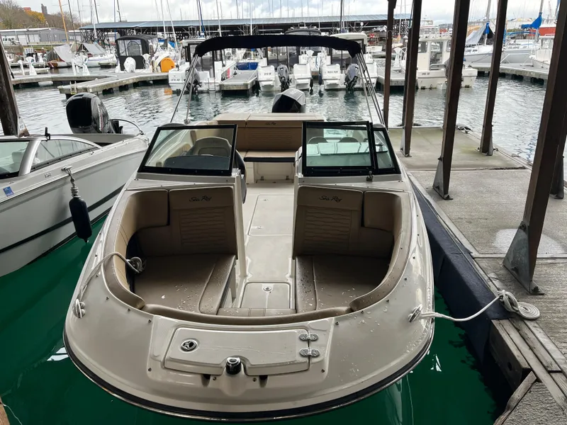 Slide: The Image of 2022 Sea Ray SPX 230 OB boat docked at marina, showcasing spacious seating and sleek design. - 2