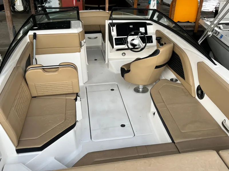Slide: The Image of 2022 Sea Ray SPX 230 OB boat interior with tan seating and modern dashboard. - 3