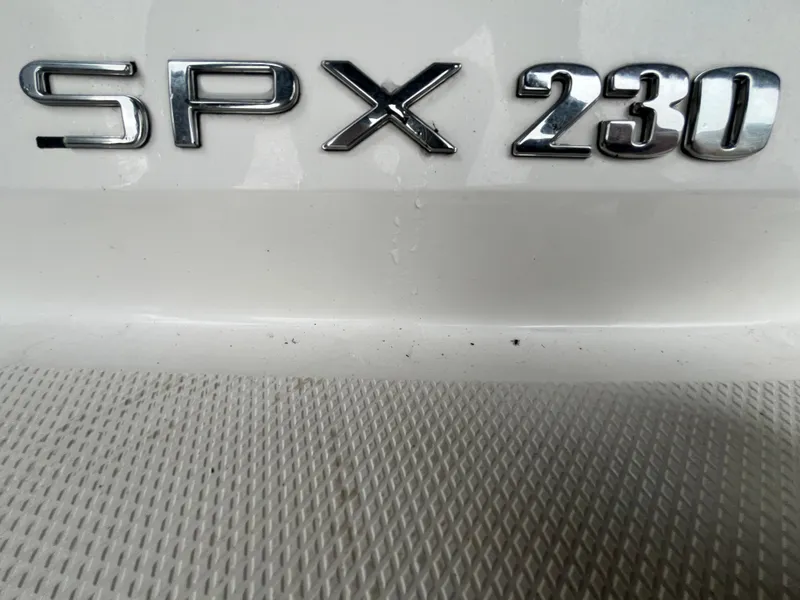 Slide: The Image of 2022 Sea Ray SPX 230 OB boat model emblem on textured surface. - 9