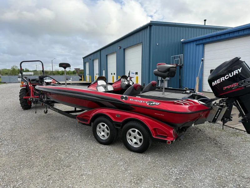 Slide: The Image of 2007 Ranger Z21 Comanche boat with Mercury engine, parked outside blue warehouse. - 4