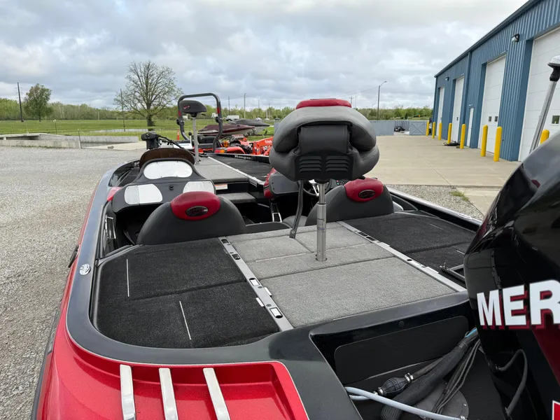 Slide: The Image of 2007 Ranger Z21 Comanche boat with red accents, parked near a blue warehouse. - 5