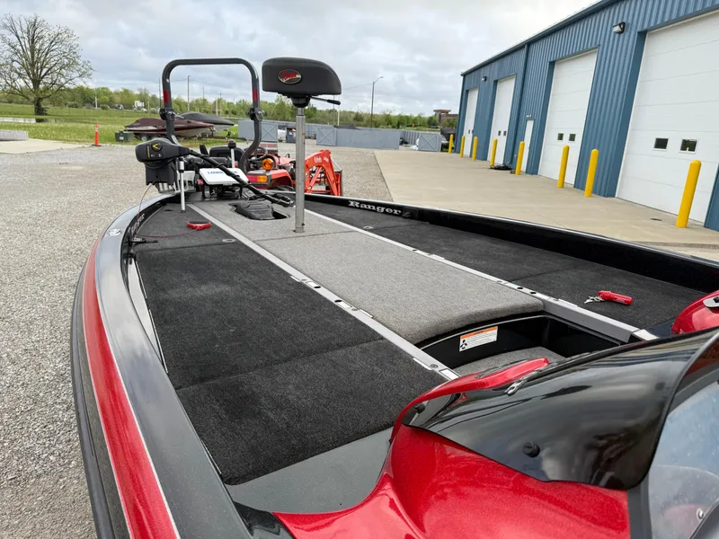 Slide: The Image of 2007 Ranger Z21 Comanche boat with red accents, parked near a blue industrial building. - 7