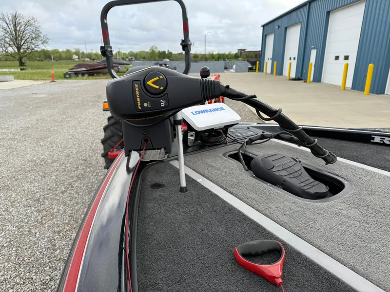 Slide: The Image of 2007 Ranger Z21 Comanche boat with Lowrance equipment, parked near a blue building. - 8