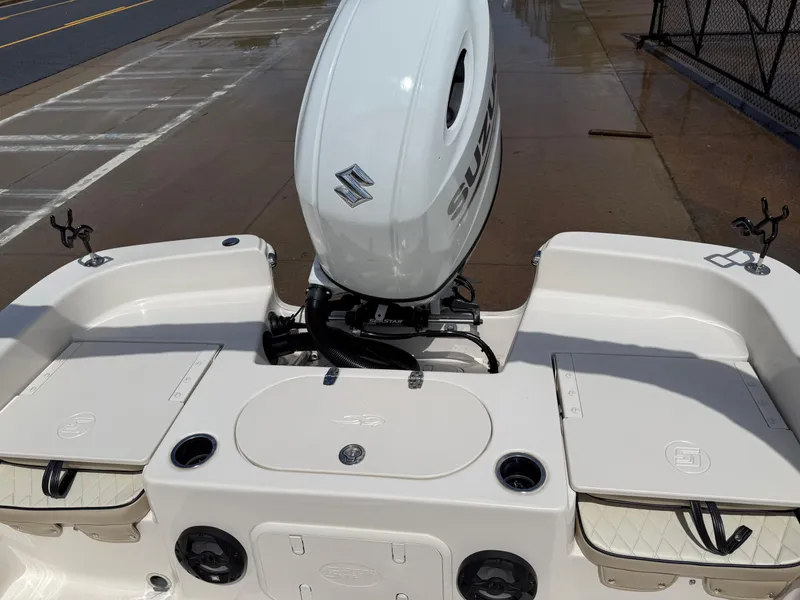 Slide: The Image of 2022 Carolina Skiff 21 LS boat with Suzuki outboard motor, docked on wet pavement. - 19