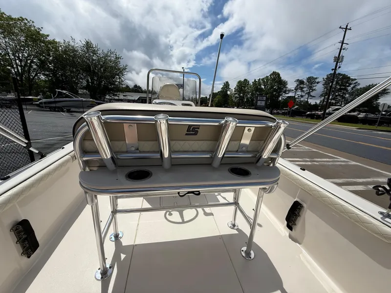Slide: The Image of 2022 Carolina Skiff 21 LS boat interior with rod holders and console, under a partly cloudy sky. - 20