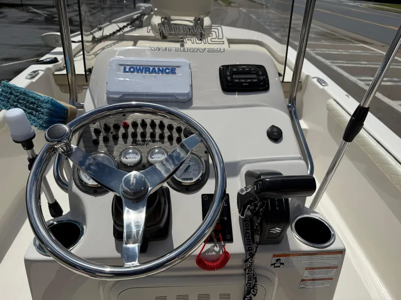 Slide: The Image of 2022 Carolina Skiff 21 LS boat dashboard with steering wheel and navigation controls. - 25