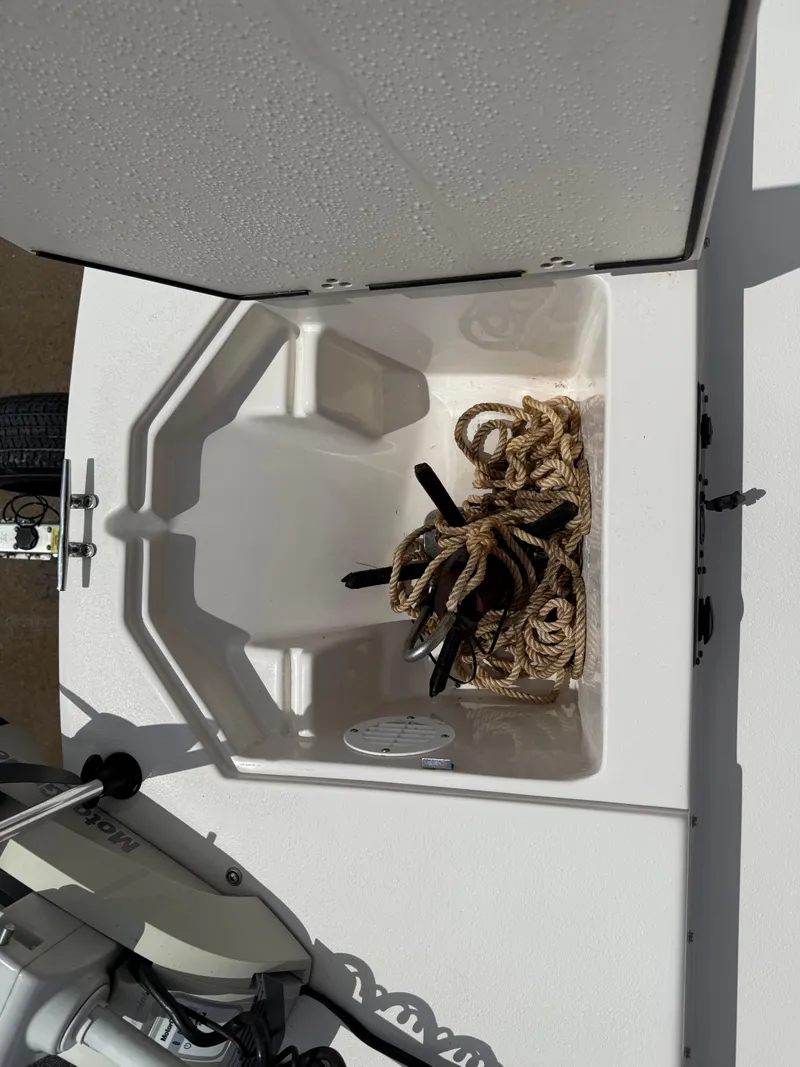 Slide: The Image of 2022 Carolina Skiff 21 LS boat storage compartment with coiled rope inside. - 34