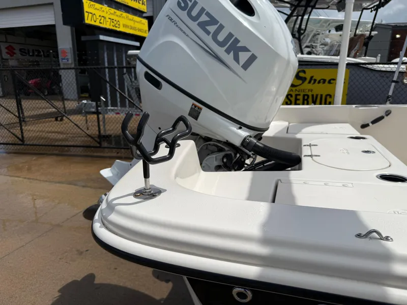 Slide: The Image of 2022 Carolina Skiff 21 LS boat with Suzuki outboard motor, docked at a marina. - 37