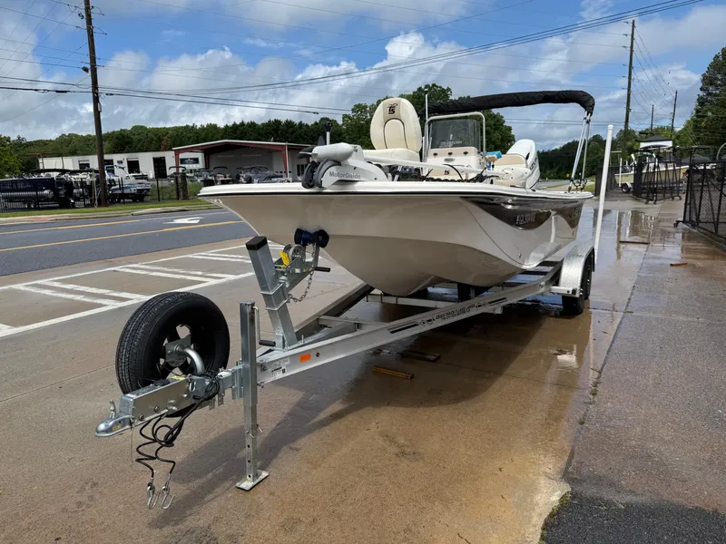 Slide: The Image of 2022 Carolina Skiff 21 LS boat on trailer, parked on wet pavement, under cloudy sky. - 42