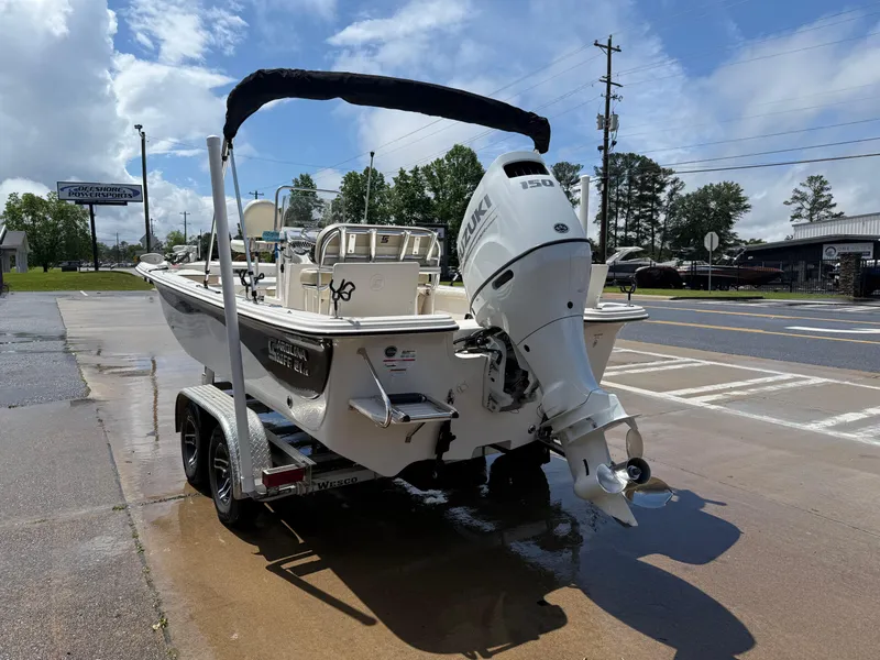 Slide: The Image of 2022 Carolina Skiff 21 LS boat on trailer, parked on wet pavement under a cloudy sky. - 5